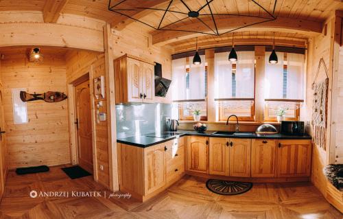 a kitchen in a log cabin with wooden cabinets at MALCYKÓWKA - domki góralskie in Ząb