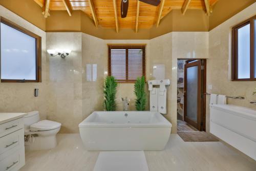 a large bathroom with a large tub and a toilet at Mount Healthy Villas 6- bedrooms with spa & pool in Tortola Island
