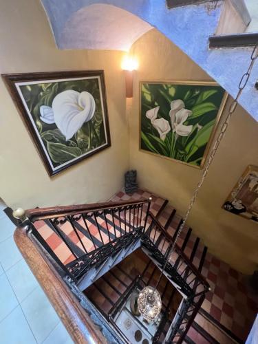 an overhead view of a staircase with paintings on the wall at La Ventana in Ibiza Town