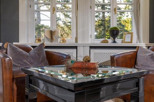a glass coffee table with a bird on top of it at Luxus Hotel Design Villa Ottilienruh Ilsenburg im Harz in Ilsenburg