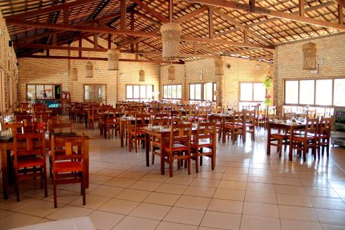 a dining room with tables and chairs in a building at Hotel Costa Atlantico in Areia Branca