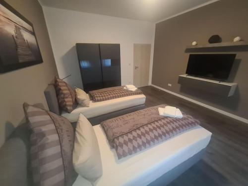 a living room with two beds and a television at Apartament Suite 3 in Bernburg