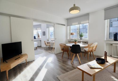 a living room with a television and a table and chairs at BOHO APARTMENT: NETFLIX + BALCONY + BATHTUB in Essen