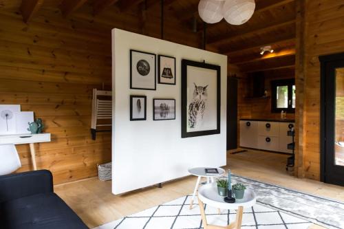 a living room with a white wall with pictures on it at FINS Holiday Home in Ermelo