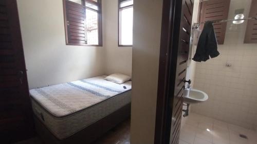 a small bedroom with a bed and a sink at Casa do Uai in João Pessoa