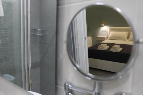 lustro w łazience z łóżkiem i prysznicem w obiekcie Zaro Suites B&B w mieście Catanzaro