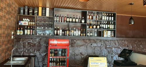 a bar with a red refrigerator and bottles of alcohol at Airport Hill Motel in Kigali