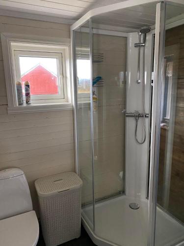 a bathroom with a shower and a toilet and a window at Borghildstua Feriehus Romslig feriehus med panoramautsikt mot havet og Lofotfjellene in Melbu