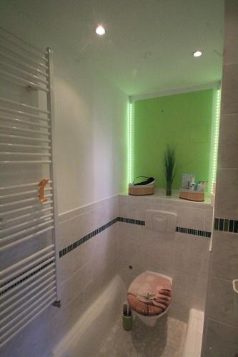uma casa de banho com uma banheira, um WC e um espelho. em Maison No.9 em Rosbach vor der Höhe