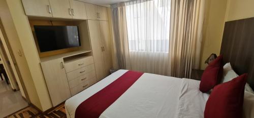a hotel room with a bed with a tv at Apart Hotel Incamin in Arequipa
