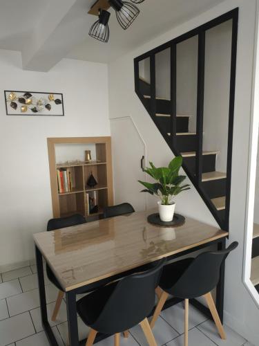 une salle à manger avec une table et des chaises en bois dans l'établissement la Lillebonnaise meublé au cœur de Lillebonne, à Lillebonne