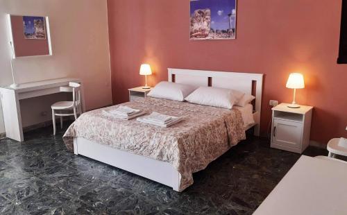ein Schlafzimmer mit einem Bett mit zwei Tischen und zwei Lampen in der Unterkunft Dimore Demetra in Canosa di Puglia