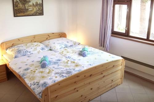 Un dormitorio con una cama de madera con dos zapatos. en Party/Wellness House Pool/Hot tub/Sauna en Pelhřimov