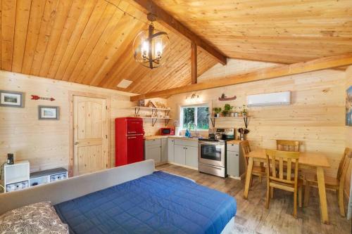 a kitchen with a blue bed and a table in a room at Cozy Cedar Cabin Steps Away From Mt. Rainier in Ashford