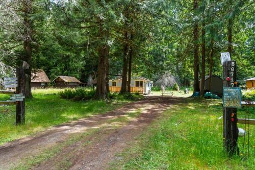 a dirt road in a field with trees and houses at Cozy Cedar Cabin Steps Away From Mt. Rainier in Ashford