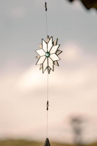 a wooden snowflake ornament hanging from a string at Chalé charmoso e aconchegante, pertinho da cidade. in Brasilia