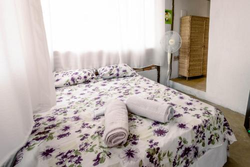um quarto com uma cama com flores roxas em Chalé charmoso e aconchegante, pertinho da cidade. em Brasília