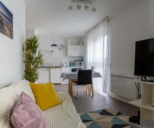 a living room with a couch and a kitchen at Studio calme, proche centre, Wifi. in Belfort