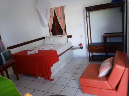 a room with a bed and a couch and a chair at Residência Pancho Villa in Canoa Quebrada