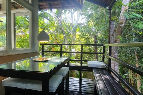 un balcon avec une table, des chaises et une fenêtre dans l'établissement Trancoso Terravista Villa Floresta, à Trancoso