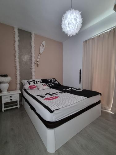 a white bedroom with a bed with a chandelier at Vistal al mar Palasiet in Era de Soler