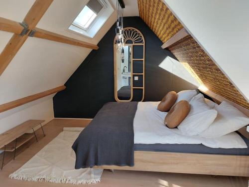 a bedroom with a large bed in a attic at Tiny house Wakker in Eemnes