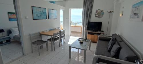a living room with a couch and a table at Atlas-Unlimited Sea View Apartment in Loutraki