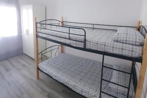 a couple of bunk beds in a room at Apartamento Sofía II a 500m de la playa con Parking solo para motos y bicicletas in Puerto de Sagunto