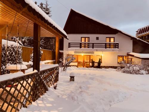 a house with snow on the ground in front of it at Cheerful 4-bedroom & kids friendly home in Predeal