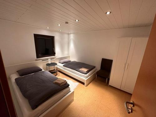a bedroom with two beds and a flat screen tv at Zimmervermietung Hirschmann Nürnberg/Messe in Nuremberg