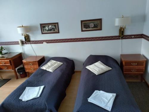 a room with two beds and two night stands at Ruukin Kievari Hotelli Ravintola in Juankoski