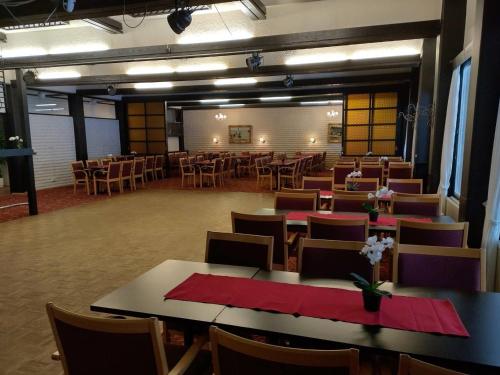 une salle à manger avec des tables, des chaises et des serviettes rouges dans l'établissement Ruukin Kievari Hotelli Ravintola, à Juankoski