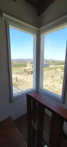 2 ventanas en una habitación con vistas al campo en Cabaña Nerviomotor en Córdoba