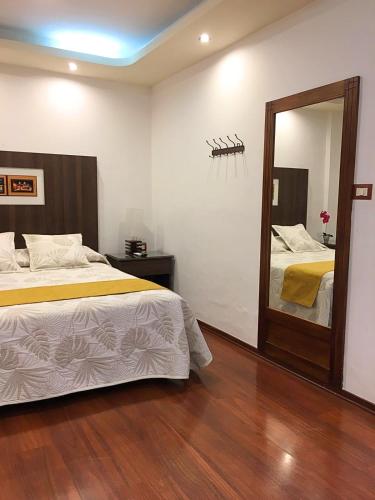 a bedroom with two beds and a large mirror at Hotel Sumaq Kay in Cumbayá