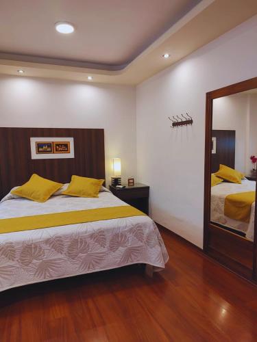 a bedroom with a large bed and a mirror at Hotel Sumaq Kay in Cumbayá