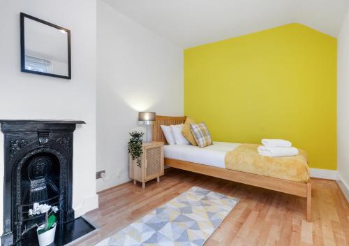 um quarto com uma cama com uma parede verde em Lovely 4 Bedroom London Home with Free Parking, Garden, WiFi By Roost Accommodation em Kingston upon Thames
