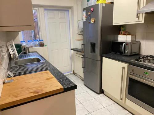 a kitchen with a sink and a refrigerator at Specious Room in Northolt in Northolt