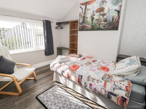 a small bedroom with a bed and a chair at The Crescent Escape in Colwyn Bay