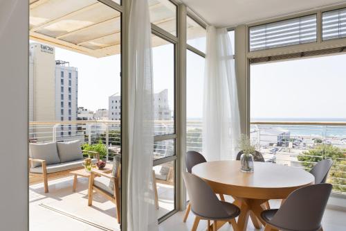 a dining room with a table and chairs on a balcony at Mate TLV PORT - By HOMY in Tel Aviv