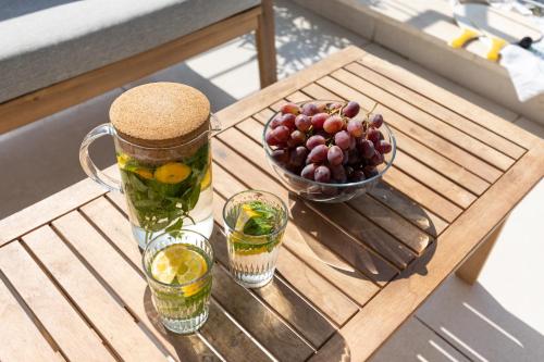 a wooden table with a pitcher and a bowl of fruit at Mate TLV PORT - By HOMY in Tel Aviv