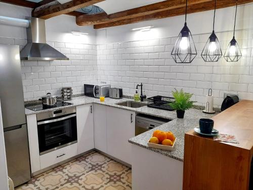uma cozinha com electrodomésticos brancos e um balcão com laranjas em Cal Passió em Vimbodí