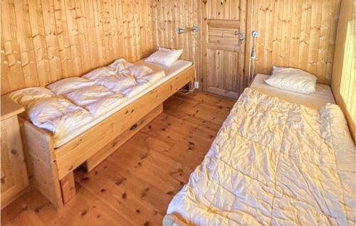 Cozy Home In Eggedal With Kitchen في Eggedal: سريرين في غرفة ذات أرضيات خشبية