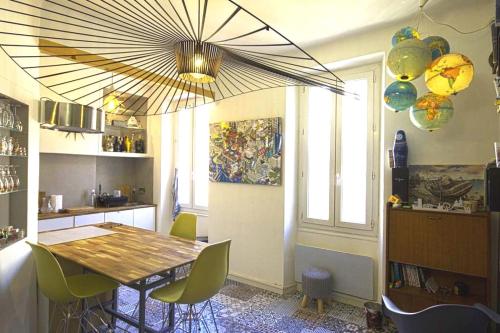 een eetkamer met een tafel en stoelen en een kroonluchter bij plein coeur du quartier du Panier . Chaleureux T2. in Marseille