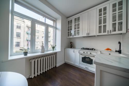 希奥利艾Nica Apartment的厨房配有白色橱柜、炉灶和窗户。