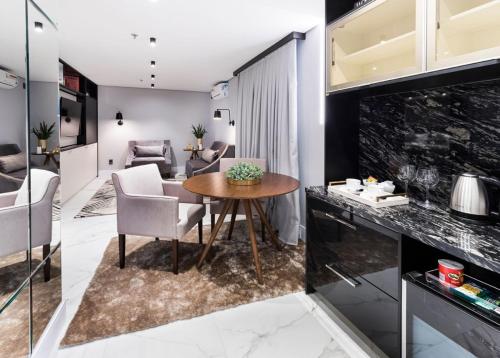 a kitchen and living room with a table and chairs at Hotel Sibara SPA & Convenções in Balneário Camboriú