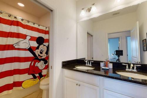 a bathroom with two sinks and an american flag at Beautiful townhouse with pool close to Disney in Davenport