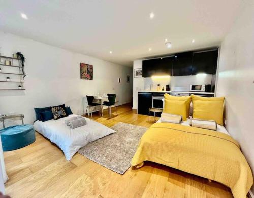 een woonkamer met 2 bedden en een keuken bij Gorgeous apartment with free parking & breakfast near city centre & midday checkout in Bristol