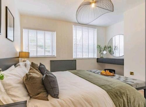 Un dormitorio con una cama grande con almohadas. en St Marg’s Hideaway; Grade II listed luxury apartment in the heart of Cheltenham - gateway to the Cotswolds! Sleeps 4 - outdoor seating and free private parking!, en Cheltenham