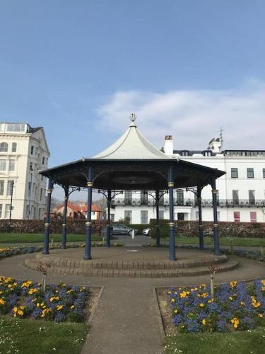 a gazebo in a park with flowers and buildings at Brooklands Filey Seaside Retreat Flat 4 in Filey