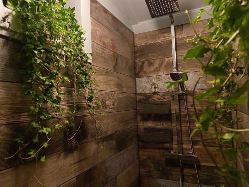 a bathroom with a shower with plants on the wall at Cosy Double Shepherds Hut In Beautiful Wicklow With Underfloor Heating Throughout in Rathnew